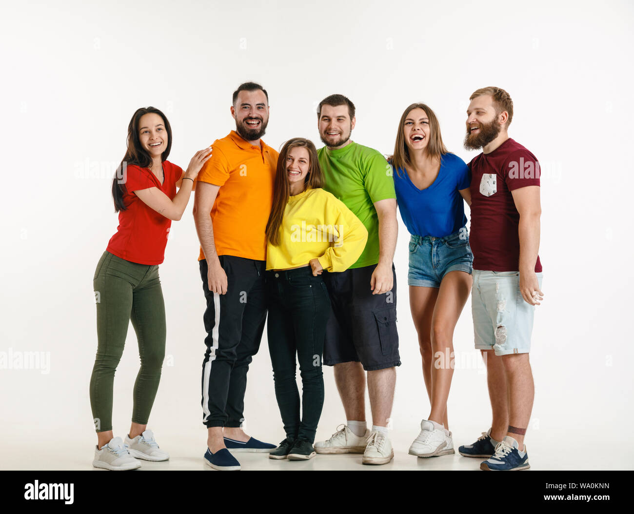 Jeune homme et femme portée au drapeau LGBT couleurs sur fond blanc. Modèles de race blanche dans des chemises. L'air heureux, souriant et serrant. La fierté LGBT, des droits de l'homme et choix concept. Banque D'Images