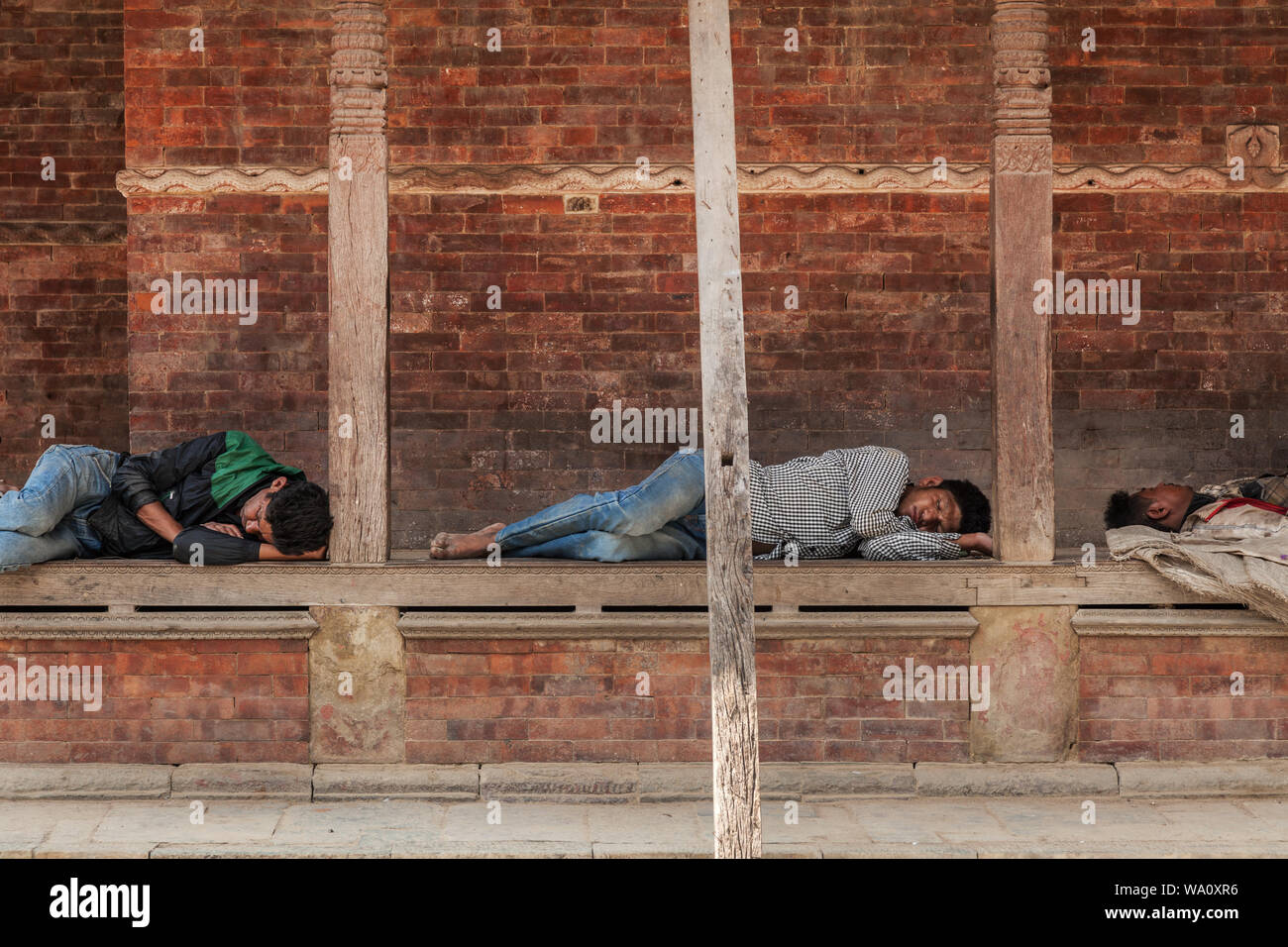 Les hommes népalais prendre du repos par un ancien temple après avoir travaillé sur les bâtiments endommagés par un tremblement de terre à Katmandou, Népal Banque D'Images Les hommes népalais prendre du repos par un ancien temple après avoir travaillé sur les bâtiments endommagés par un tremblement de terre à Katmandou, Népal Banque D'Images