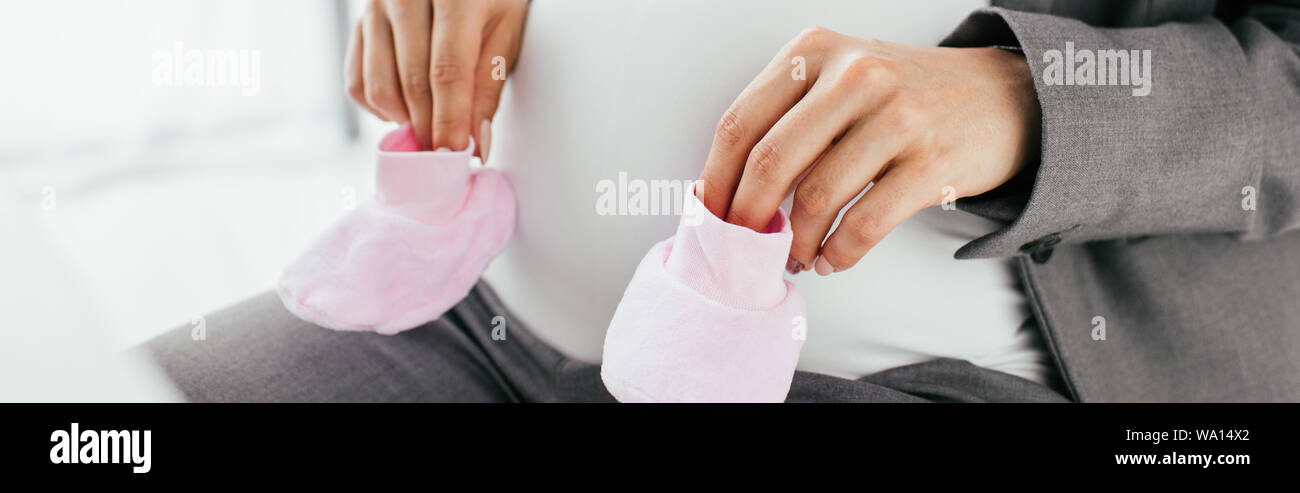Vue panoramique de pregnant woman holding chaussons rose Banque D'Images