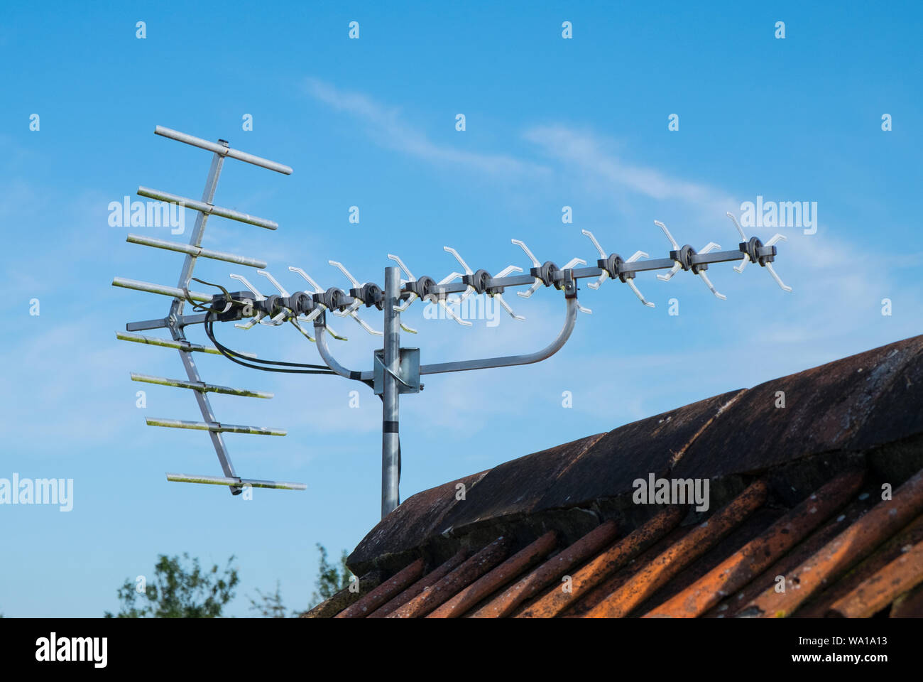 Une antenne TV numérique sur le toit d'une maison contre un ciel bleu Photo  Stock - Alamy
