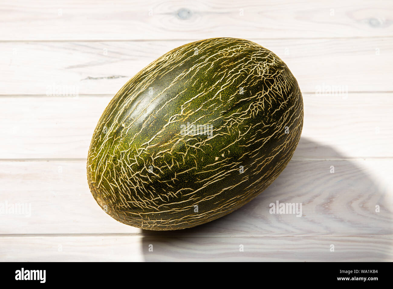 Melon frais isolé sur fond de bois blanc. Cucumis melo Banque D'Images