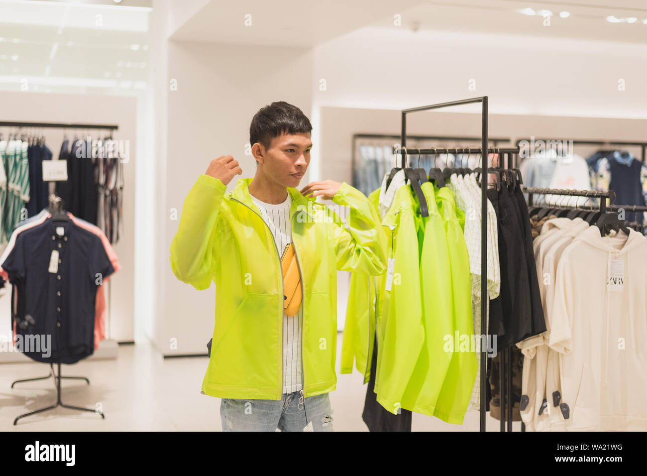 Bangkok, Thaïlande - Mai 19, 2019 : un jeune homme tente sur un  semi-transparente veste fluorescent néon de couleur chaux dans un magasin  Zara Photo Stock - Alamy