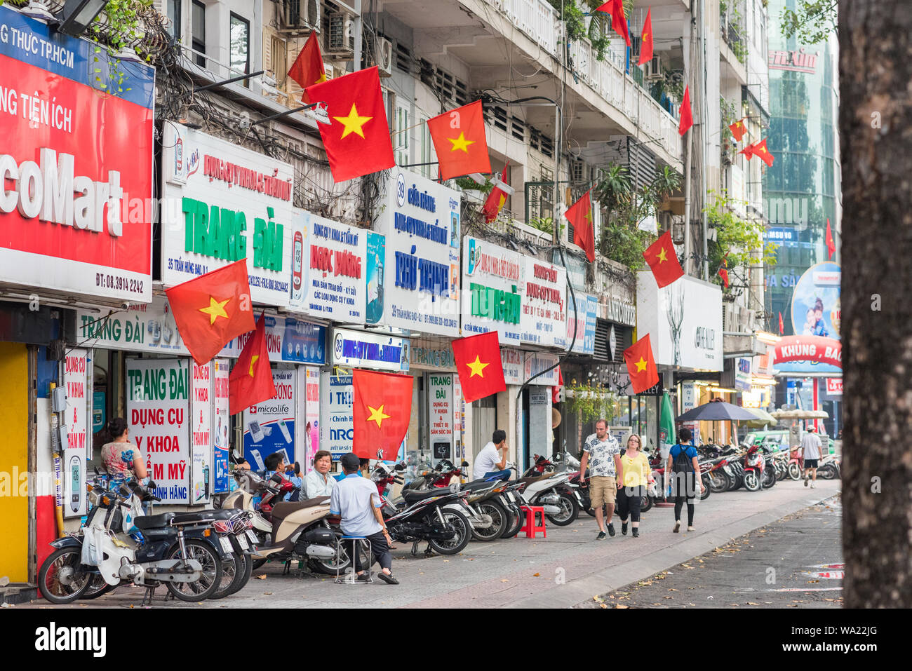Ho Chi Minh, Vietnam : Tran Hung Dao Street décorée de drapeaux vietnamiens à la veille de la réunification de la journée et de la Journée internationale du Travail. Banque D'Images