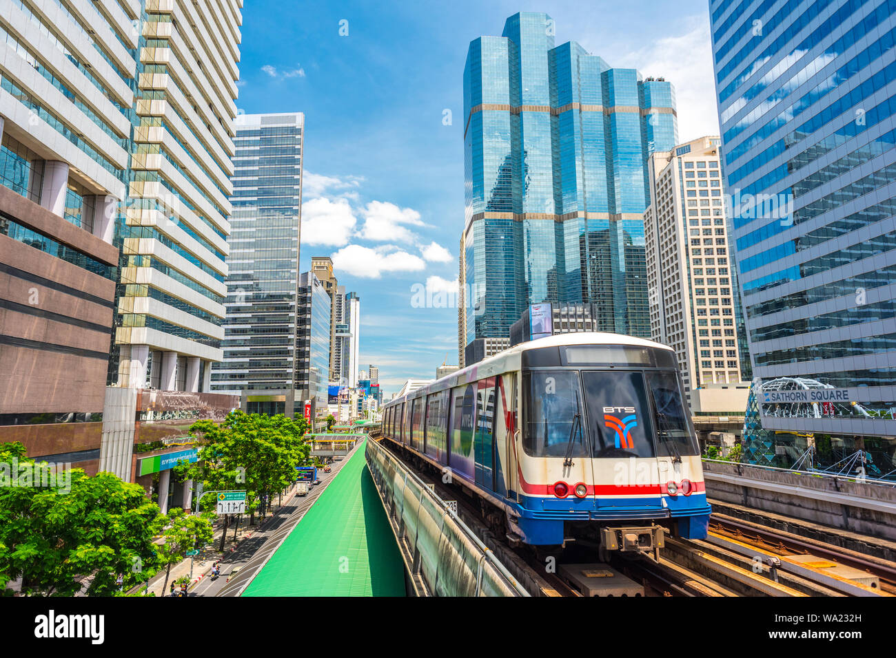 Bangkok, Thaïlande - 9 juin 2019 : un train de BTS (Skytrain) voyages entre les gratte-ciel du centre-ville (Bang Rak district). Banque D'Images