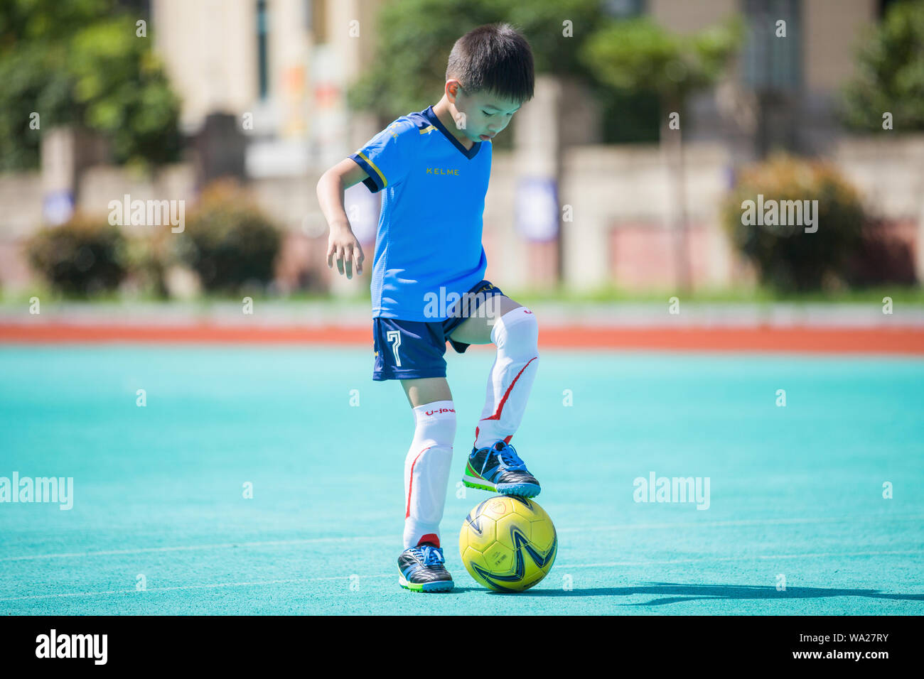 Le garçon jouant au football Banque D'Images