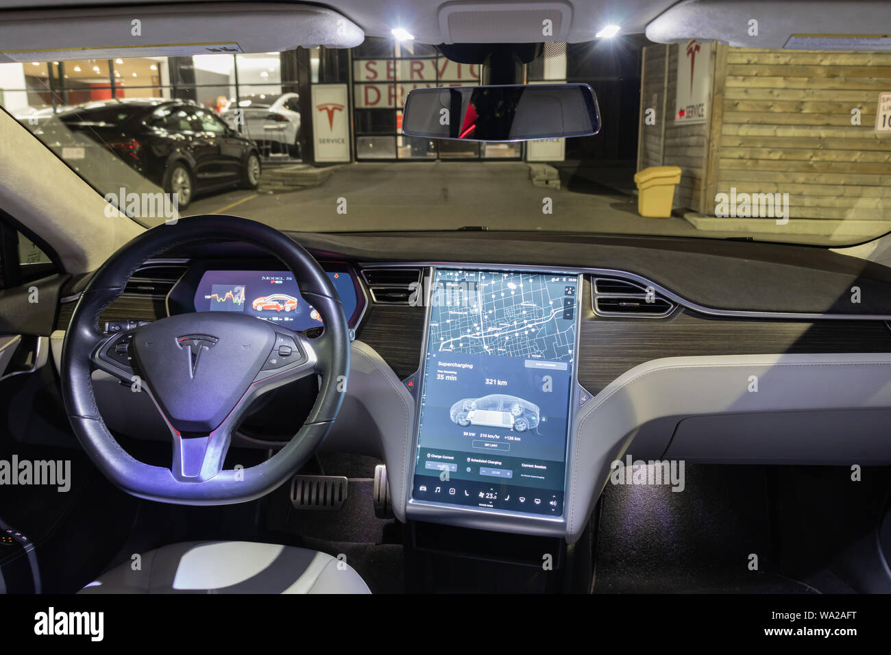 En vue complète de Tesla Model S intérieur, vu un soir alors que les frais de véhicule chez Tesla Supercharger à un centre de service. Banque D'Images En vue complète de Tesla Model S intérieur, vu un soir alors que les frais de véhicule chez Tesla Supercharger à un centre de service. Banque D'Images