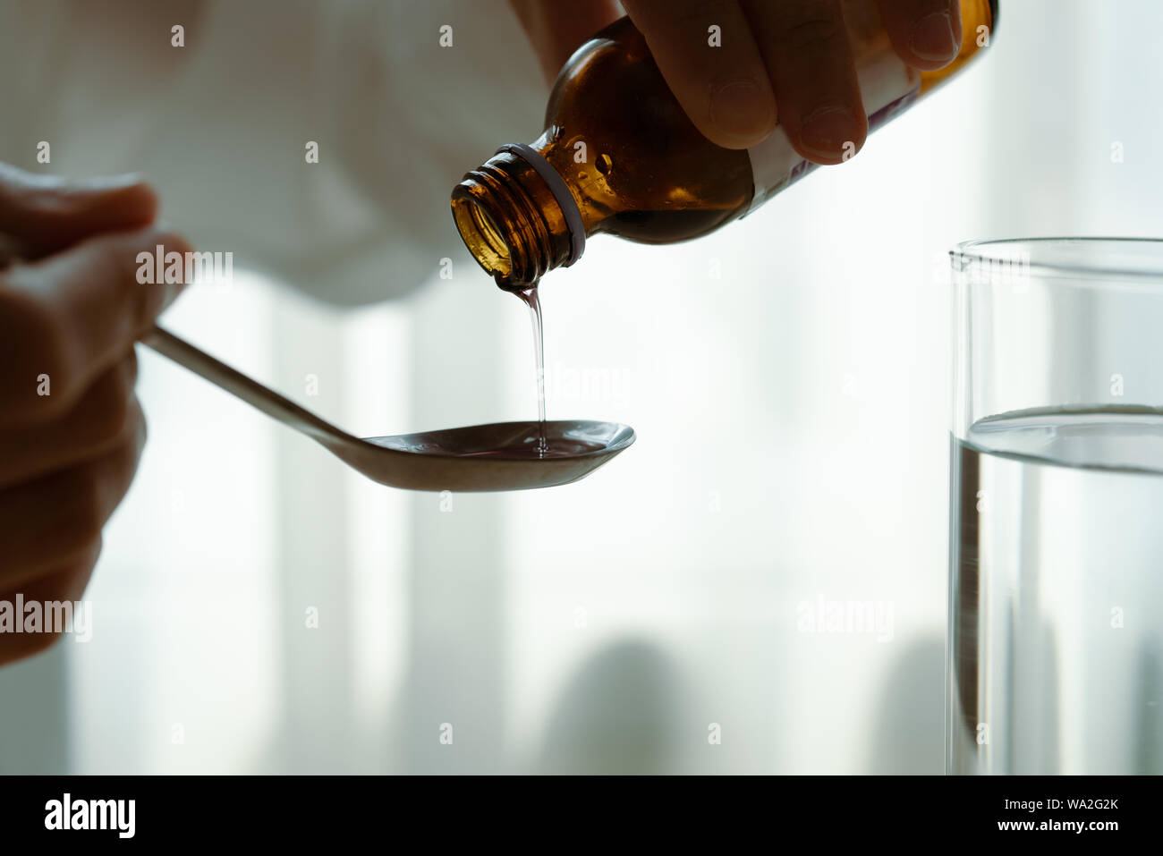 Woman pouring médicaments ou du sirop contre la toux du biberon à la cuillère. concept de soins de santé Banque D'Images