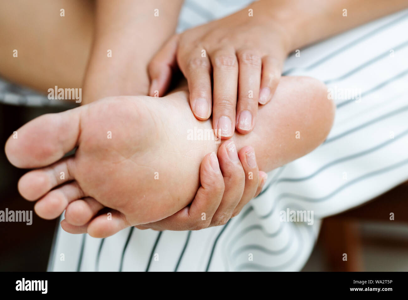 Femme en massant son douloureux pieds nus, les soins de santé et concept médical Banque D'Images