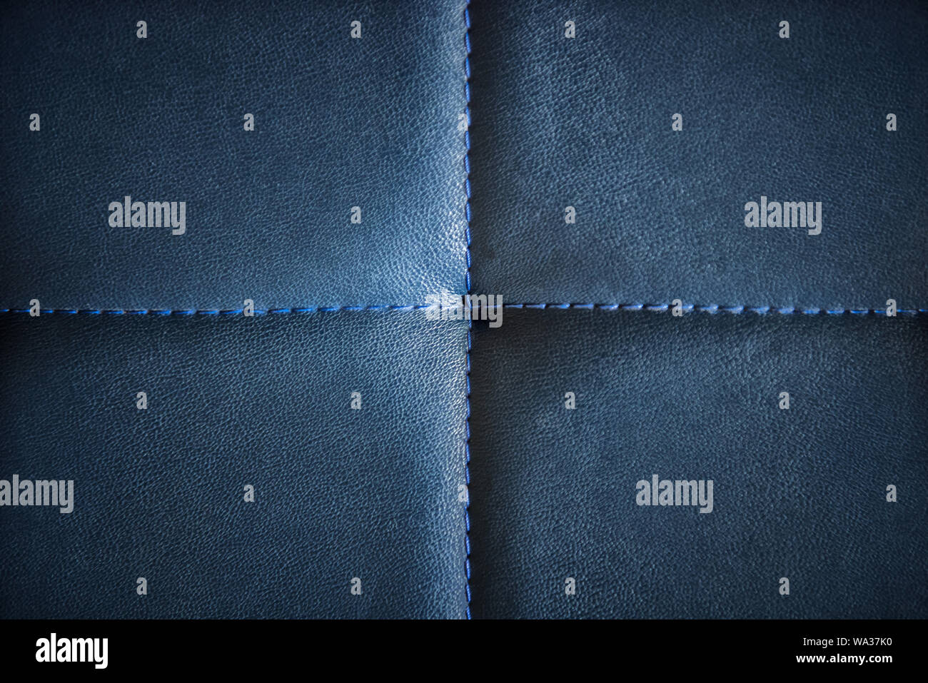 Bleu foncé en cuir artificiel piqué avec fil bleu. Close-up de canapé-surface. Voir à partir de juste au-dessus. Avec l'arrière-plan très détaillé Banque D'Images