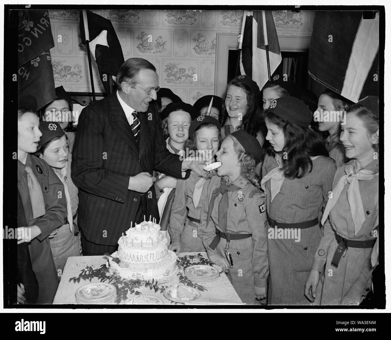 L'Ambassadeur Birtish aide les Girl Scouts au 28e anniversaire de la partie. Washignton D.C., 12 mars. Lord Lothian, ambassadeur britannique aux États-Unis, sont venus s'amuser, mais au lieu de cela, a diverti les Girl Scouts à leur siège social ici aujourd'hui à l'occasion du 28e anniversaire de la fondation de l'organisation, à la suite d'une radio à l'adresse 572 000 les éclaireuses du monde entier, l'Ambassadeur Lothian connaît son apogée la partie par l'alimentation d'un morceau du gâteau d'anniversaire pour fille de 11 ans du scoutisme Winifred McGowan de 138 troupes, 3-12-40 Banque D'Images