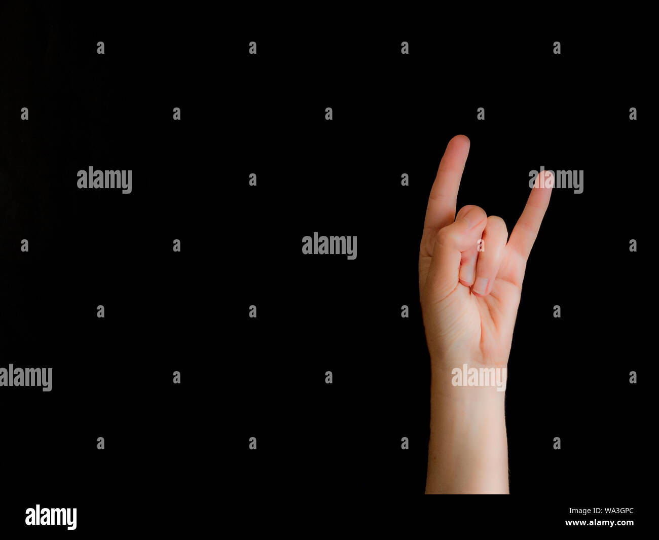 La main avec cornes signe sur fond noir avec copie espace Banque D'Images