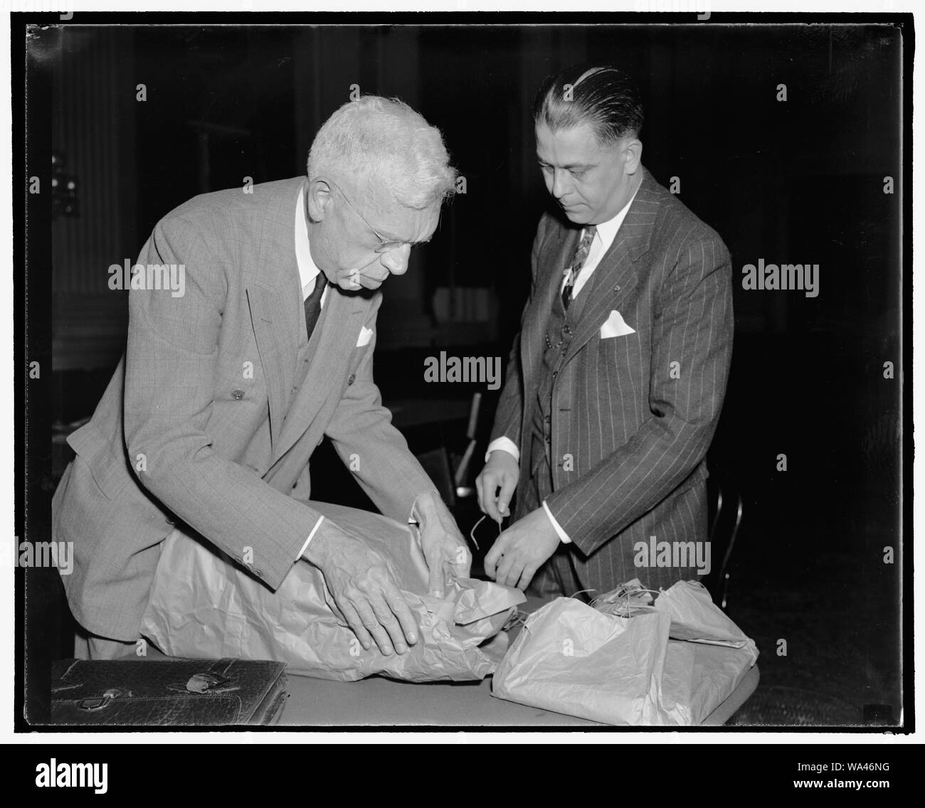 Les ponts un communiste, les responsables de la Légion de se charger avant de comité de la Chambre. Washington, D.C., le 24 octobre. Harper Knowles, droite, Président du Comité de recherche de radical de la Légion américaine, et Ray Nimmo, l'avocat de la même commission, à emballer leur masse de preuves après la charge devant le comité de la Chambre sur les activités antiaméricaines que Harry Bridges, chef syndical, est un membre de la section du front du parti communiste. Nimmo interrogé Knowles devant le comité pour faire ressortir leurs accusations. Les deux hommes sont de la Californie, du 10/24/38 Banque D'Images