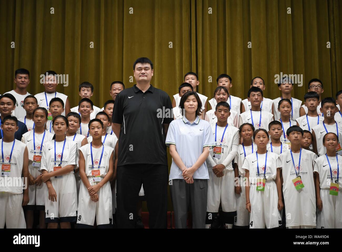 Yao Ming, le plus haut, enseigne à l'Yao-Foundation peu basketballers-parrainé la compétition de basket-ball dans la ville de Tongren, de la province du Guizhou, au sud-ouest de la Chine, 16 août 2019. Yao Ming, un exécutif de basket-ball chinois et ancien joueur professionnel basketballplayer, et son épouse Ye Li, un joueur professionnel de basket-ball chinois, montrer et prendre des photos avec plus de 400 Peu de joueurs de basket-ball de l'Yao-Foundation-parrainé la compétition de basket-ball, qui est composé d'équipes nationales de l'espoir les écoles primaires, dans la ville de Tongren, de la province du Guizhou, au sud-ouest de la Chine, 16 août 2019. Banque D'Images