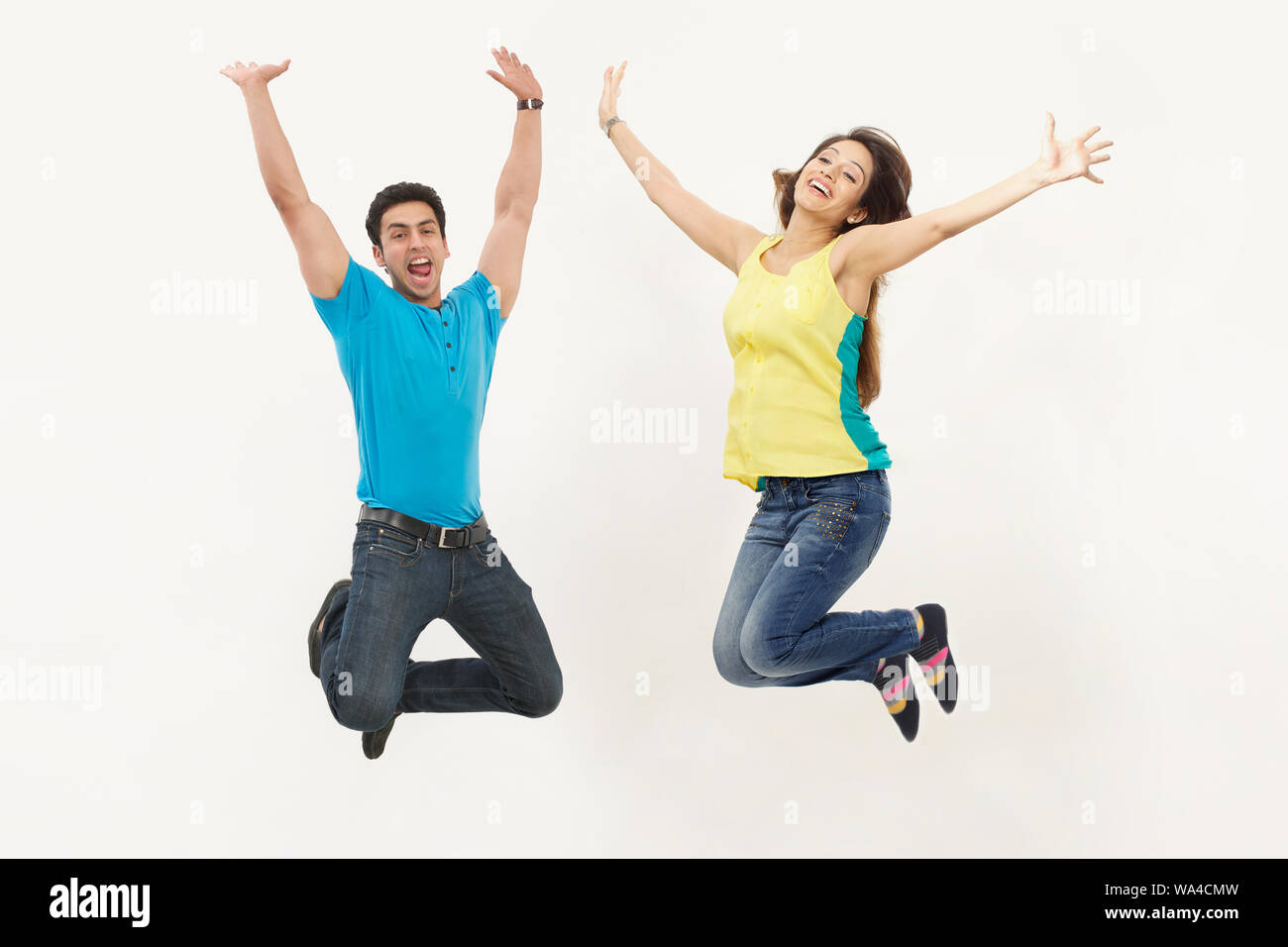 Jeune couple de sauter dans l'air Banque D'Images