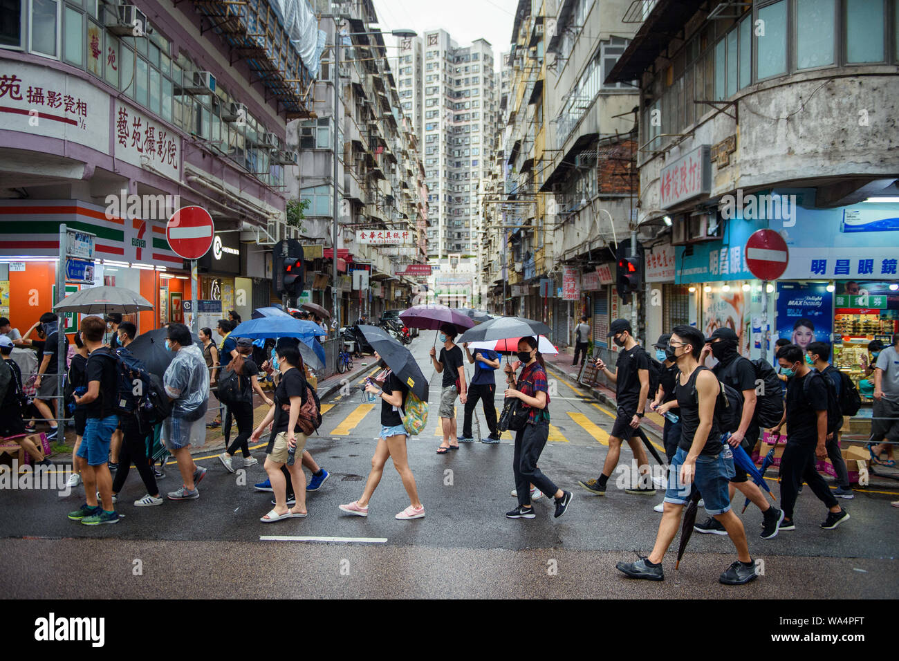 Hong Kong, Chine. Août 17, 2019. Les participants d'une manifestation de protestation à travers le district de Hong Kong, Kowloon et se protéger avec des parasols de la pluie. À Hong Kong il y a eu des protestations massives pendant plus de deux mois maintenant. Les manifestations ont été déclenchées par un projet de loi du gouvernement - en attente - d'extrader des suspects à la Chine. Credit : Gregor Fischer/dpa/Alamy Live News Banque D'Images