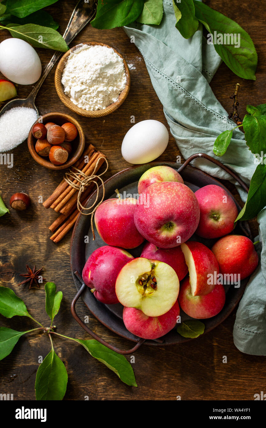 Cuisson Apple concept de saison. Ingrédients pour la tarte aux pommes (pomme rouge, la farine, les oeufs, l'anis, le sucre, les noisettes et la cannelle) sur une table en bois rustique. Top v Banque D'Images