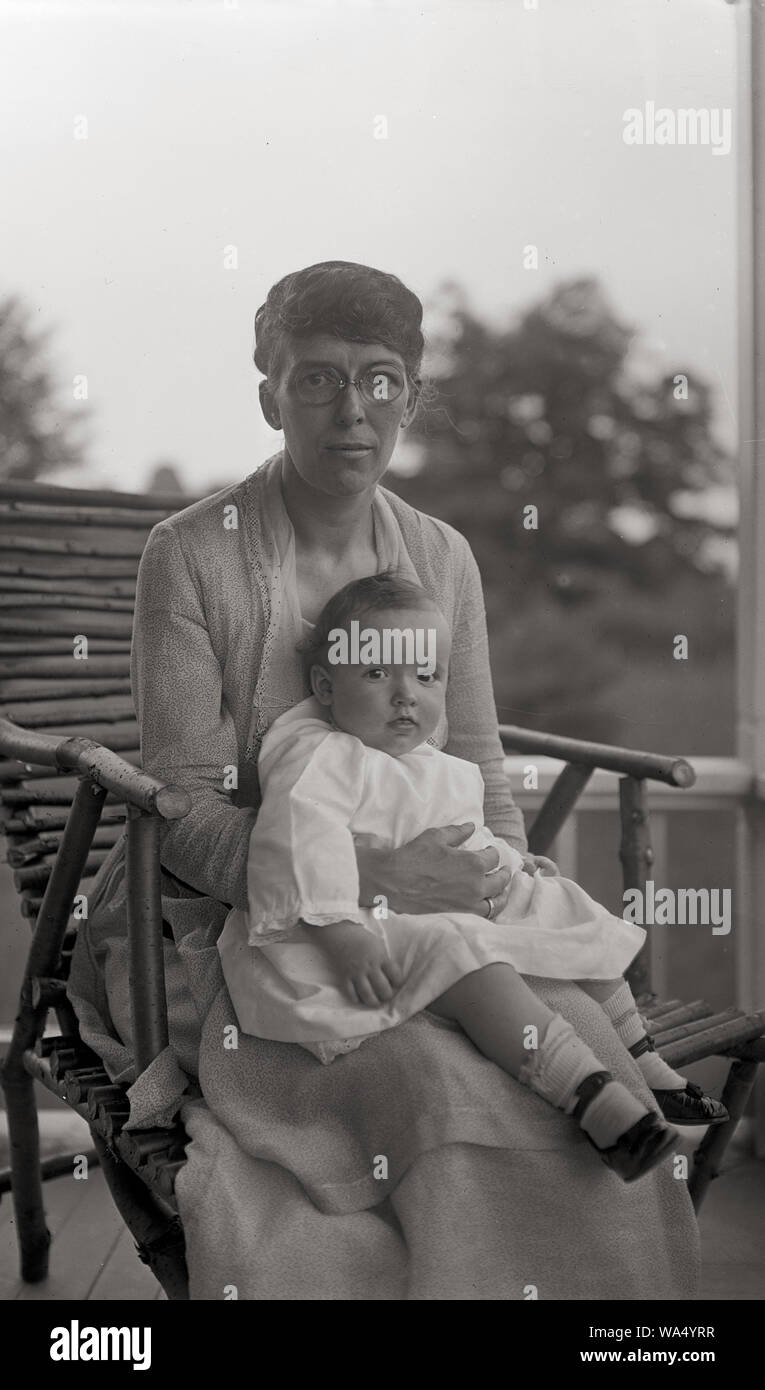 Femme et enfant sur le porche d'une maison de campagne . Portraits de famille vers 1920. Banque D'Images