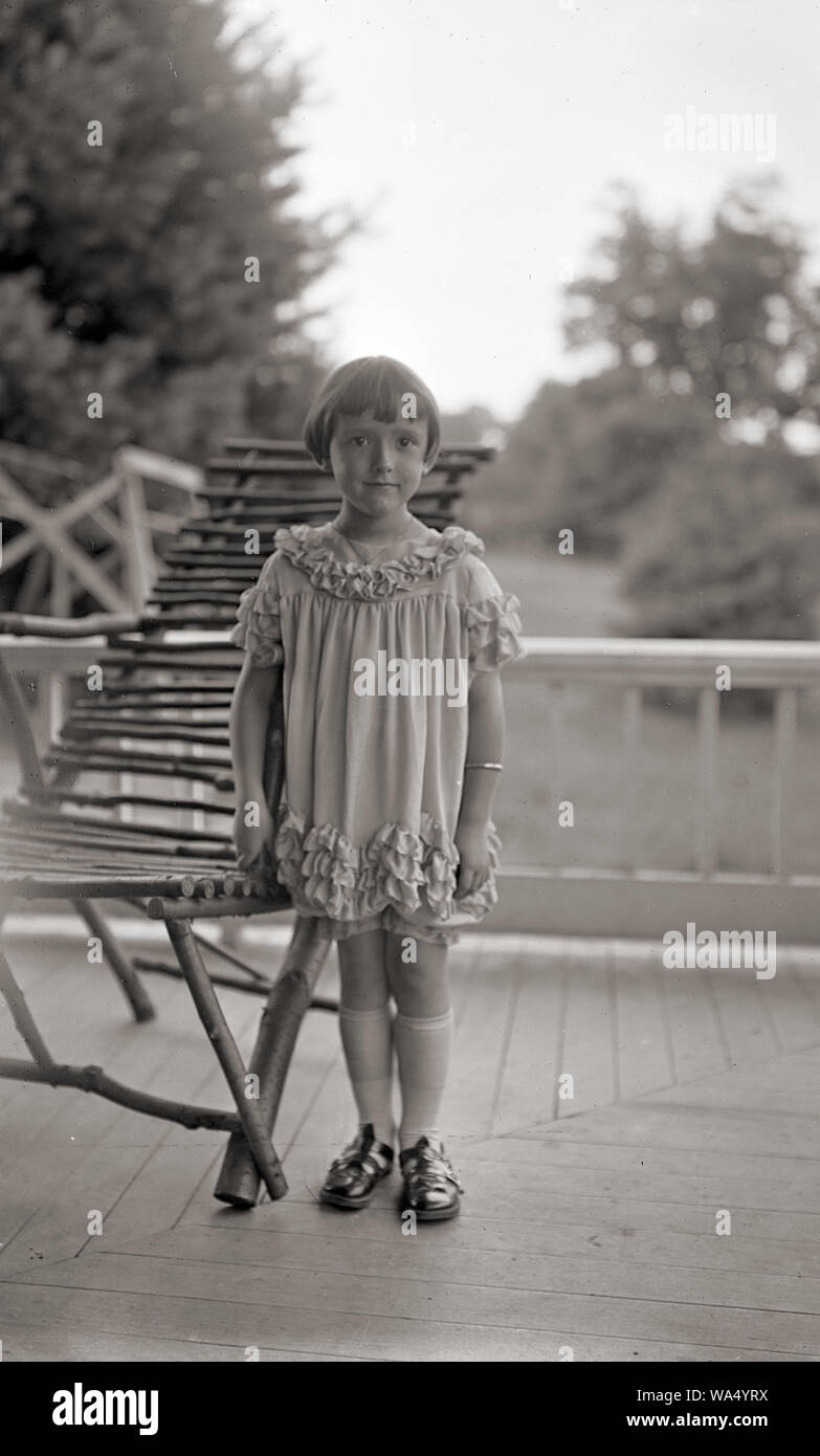 Jeune fille sur le porche d'une maison de campagne . Portrait de famille vers 1920. Est des États-Unis Banque D'Images