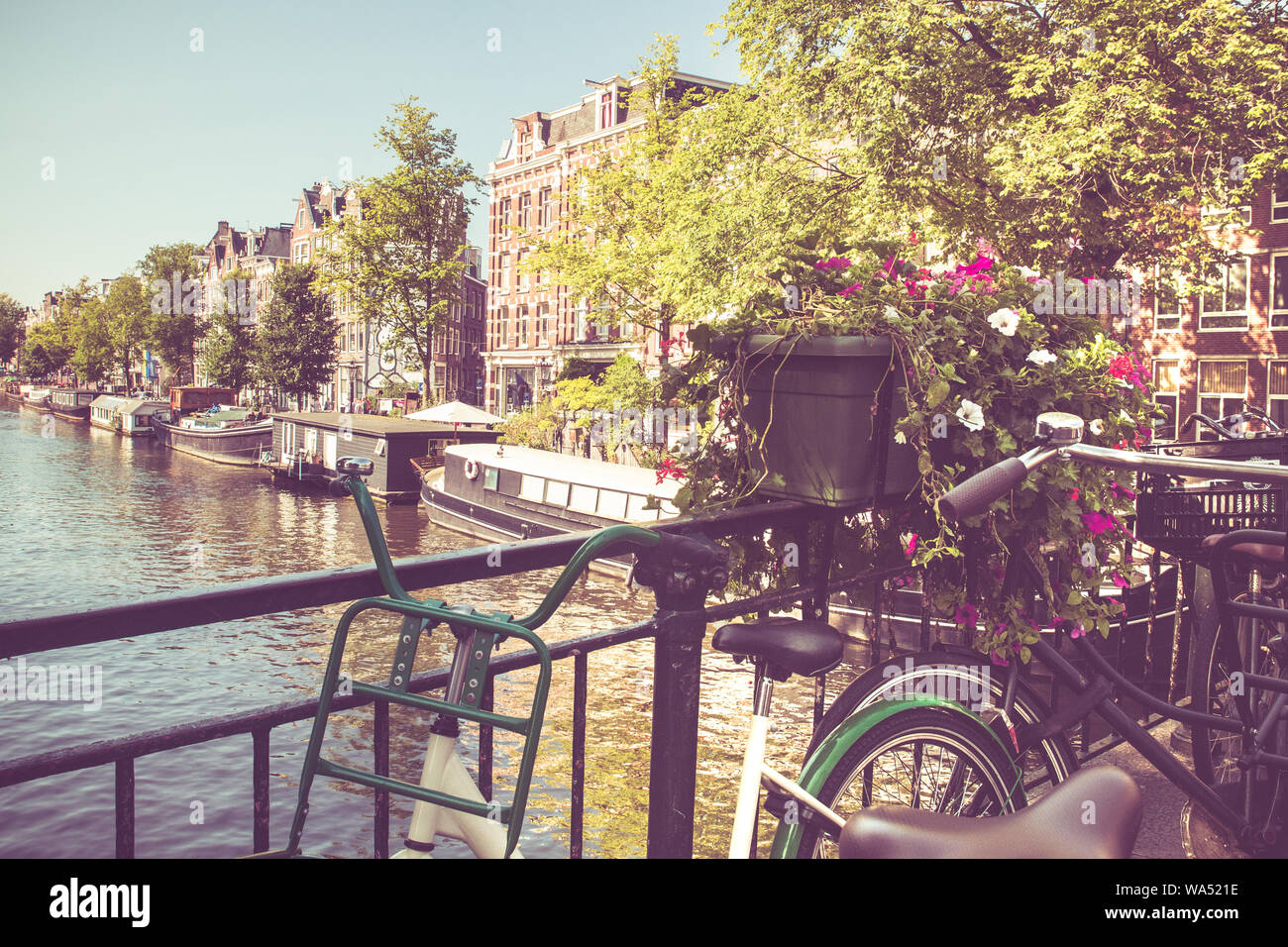 Amsterdam avec des vélos sur le pont sur un canal avec filtre de tonalité vintage. Banque D'Images