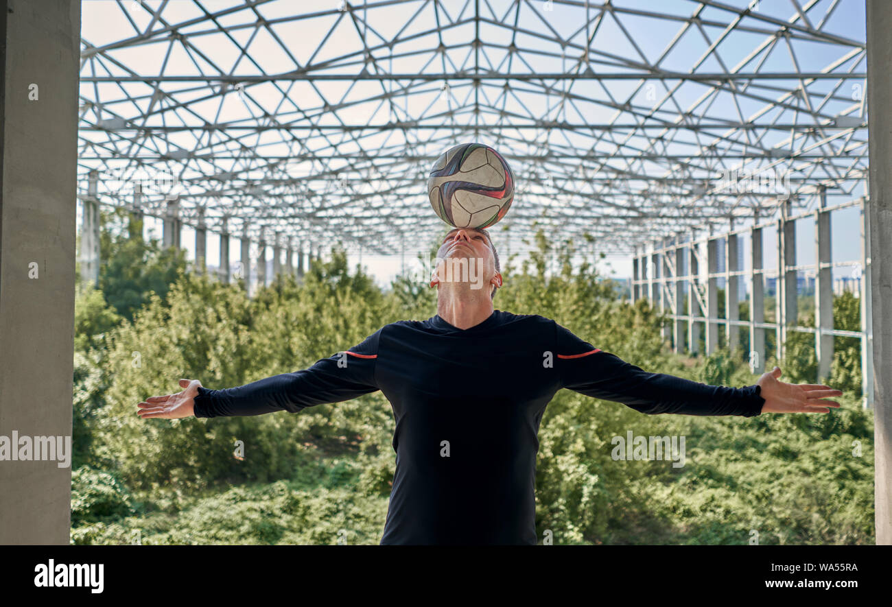 Joueur de football avec le ballon à l'immeuble Banque D'Images