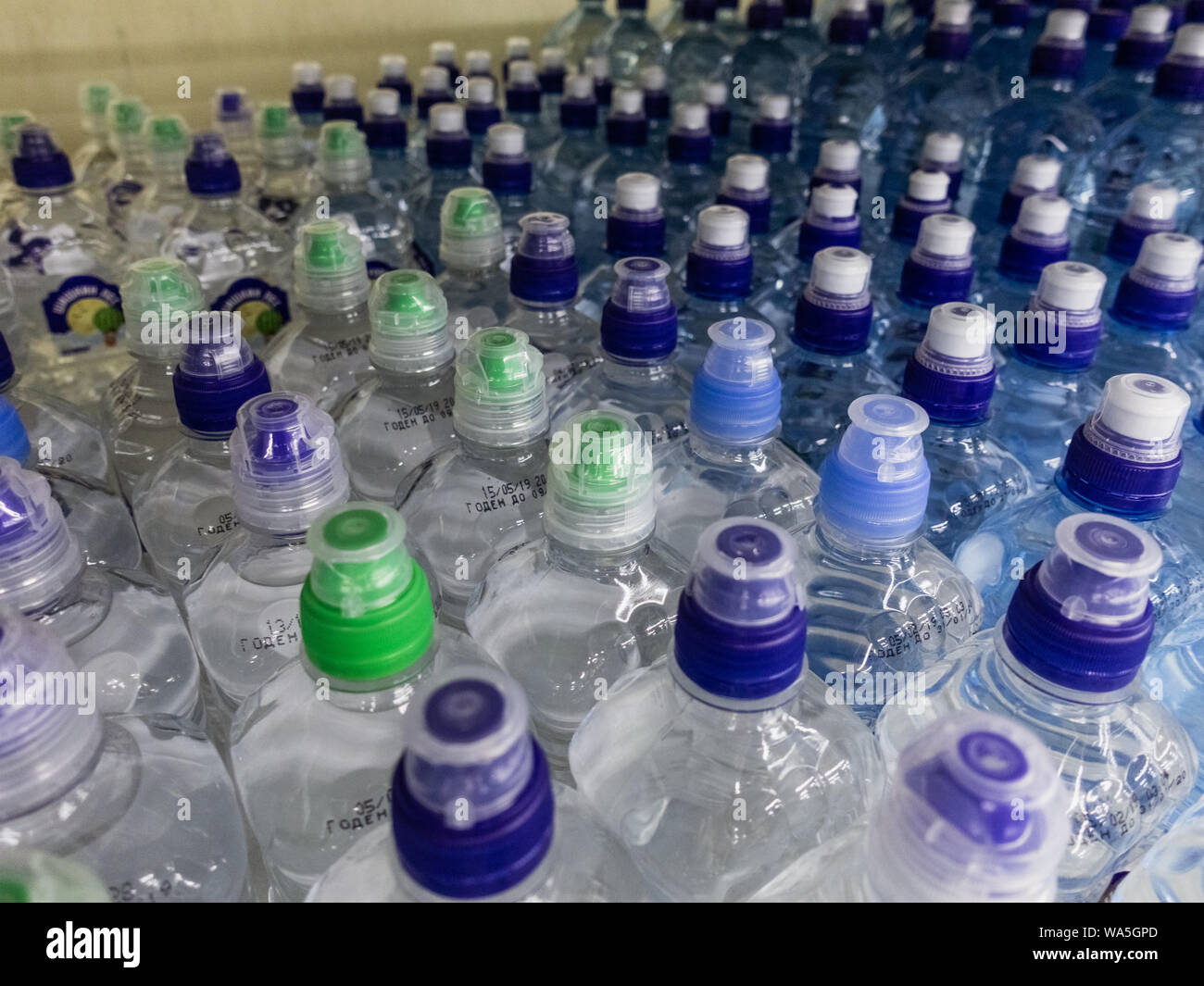 Les bouteilles en plastique avec wate. Rangées de bouteilles en plastique remplies d'eau avec bouchons à vis. Banque D'Images