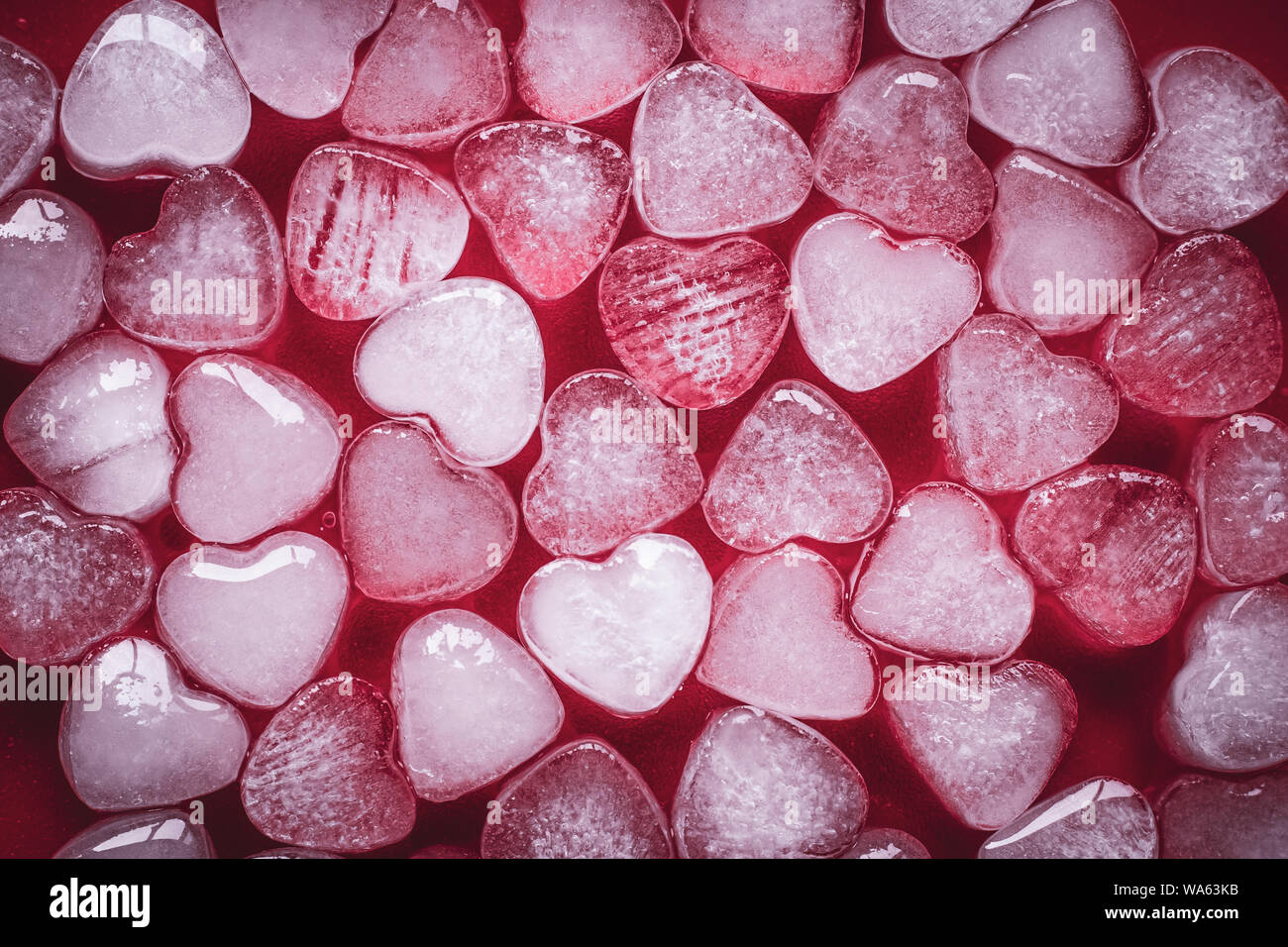 Coeur de glace sur fond rouge. Love abstraction. Laconic concept design dans un style moderne. Carte romantique avec des coeurs gelés. Symbole de la Saint-Valentin. Banque D'Images