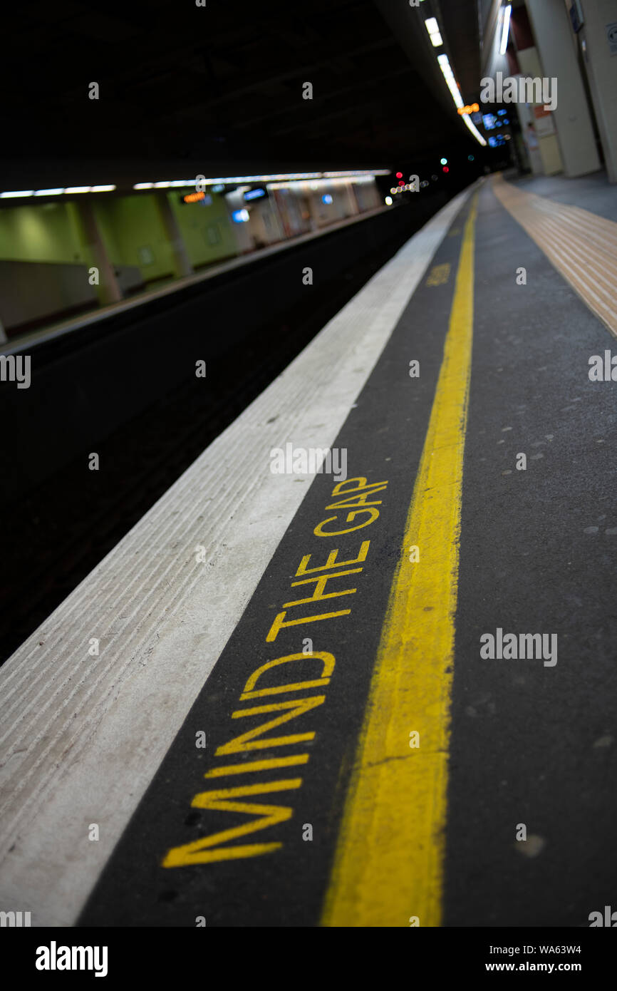 L'écriture sur le bord de la plate-forme du train met en garde les passagers de l'écart entre le train et la plate-forme. Banque D'Images