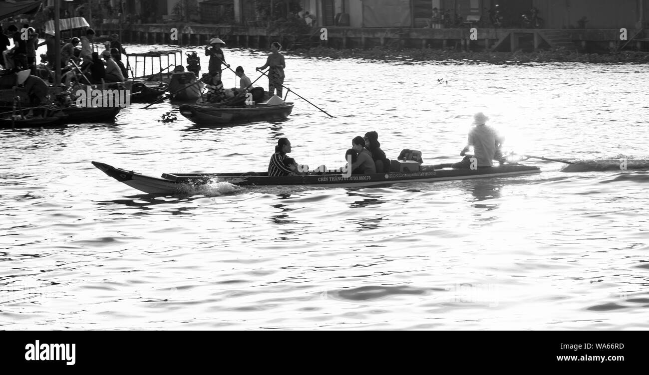 Batelier de l'aviron et le transport de passagers sur la rivière au coucher du soleil dans le Delta du Mékong, Soc Trang Vietnam Banque D'Images
