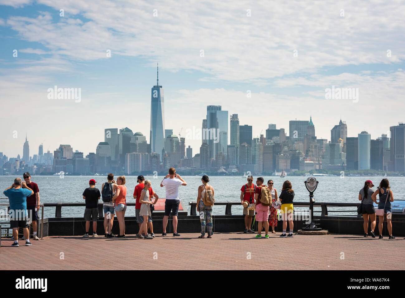 Les gens de la ville de New York, vue en été de touristes sur Liberty Island à la recherche vers le Quartier Financier de Manhattan skyline, NEW YORK, USA Banque D'Images
