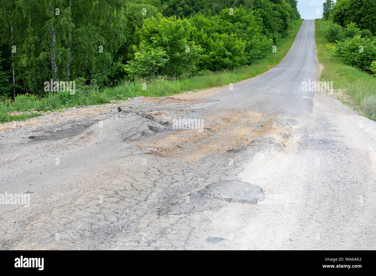 Mauvaise route pour voitures, cassé, fêlé la surface du couvercle d'urgence de l'asphalte. Banque D'Images