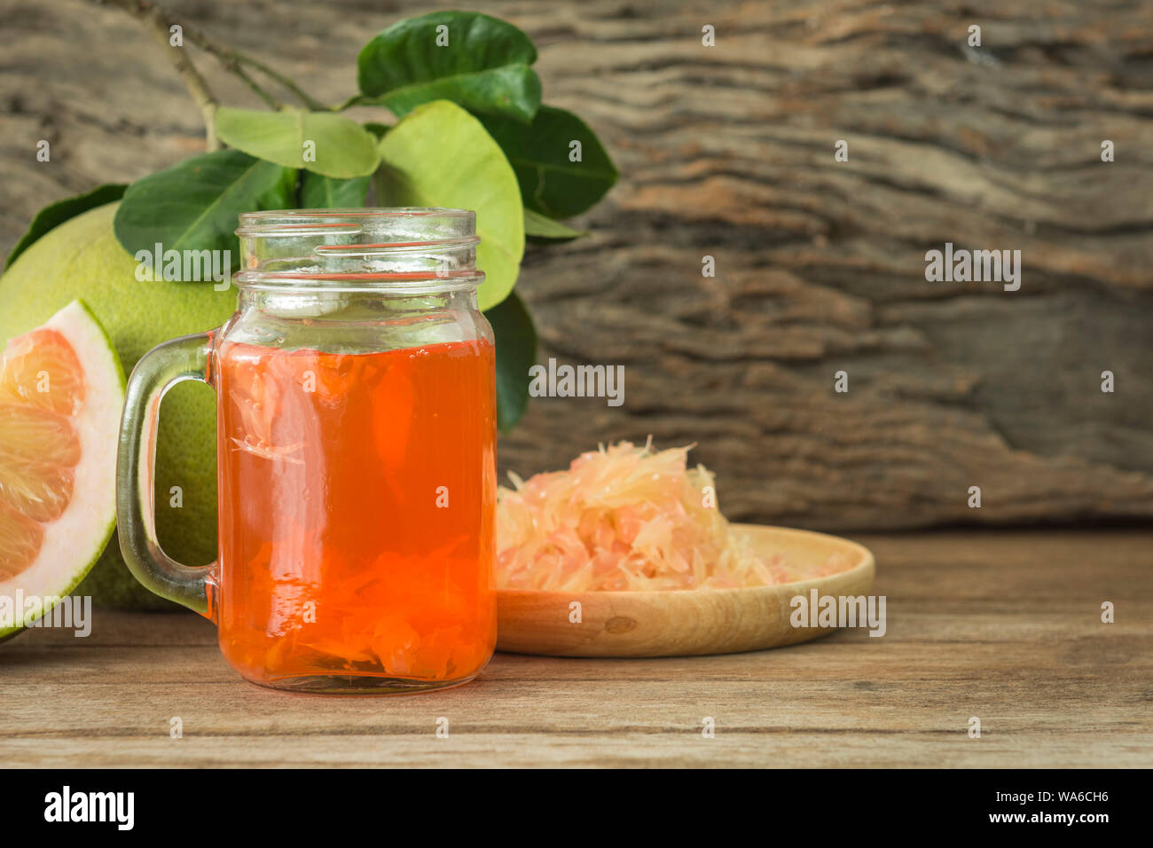 Jus de pamplemousse frais dans un verre sur une table en bois. Banque D'Images