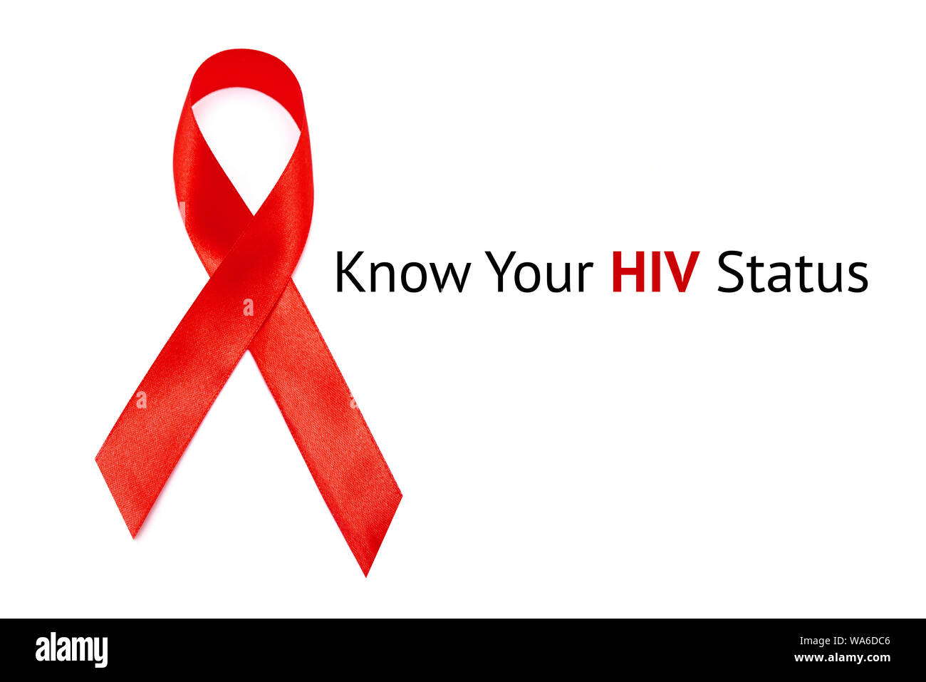 Connaître votre statut VIH inscription sur fond blanc et ruban rouge comme symbole de la LUTTE CONTRE LE VIH ET LE SIDA Banque D'Images