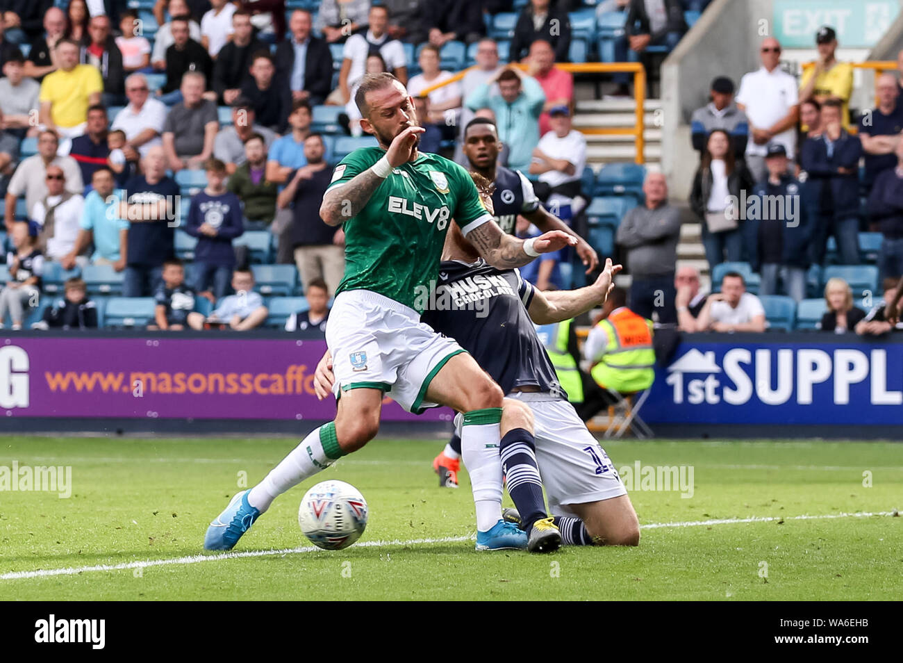 Steven Fletcher de Sheffield mercredi est abordé par Alex Pearce de Millwall pendant l'EFL Sky Bet match de championnat entre Millwall et Sheffield Wednesday à la Den, Londres, Angleterre le 17 août 2019. Photo de Ken d'Étincelles. Usage éditorial uniquement, licence requise pour un usage commercial. Aucune utilisation de pari, de jeux ou d'un seul club/ligue/dvd publications. Banque D'Images