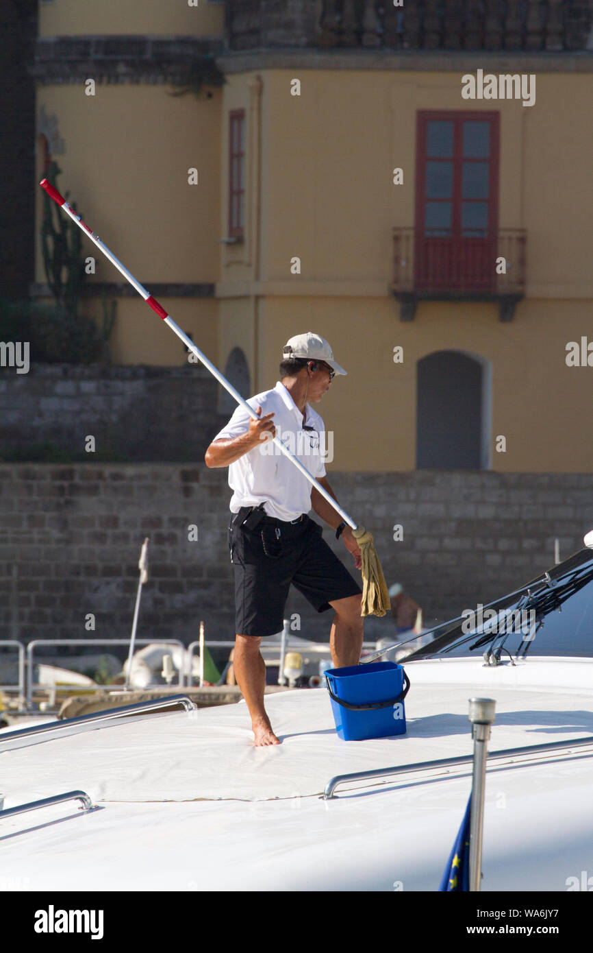 Homme utilisant un long balai à franges pour nettoyer le pont d'un bateau  amarré dans une marina à Sorrente, côte amalfitaine, Italie, Europe Photo  Stock - Alamy
