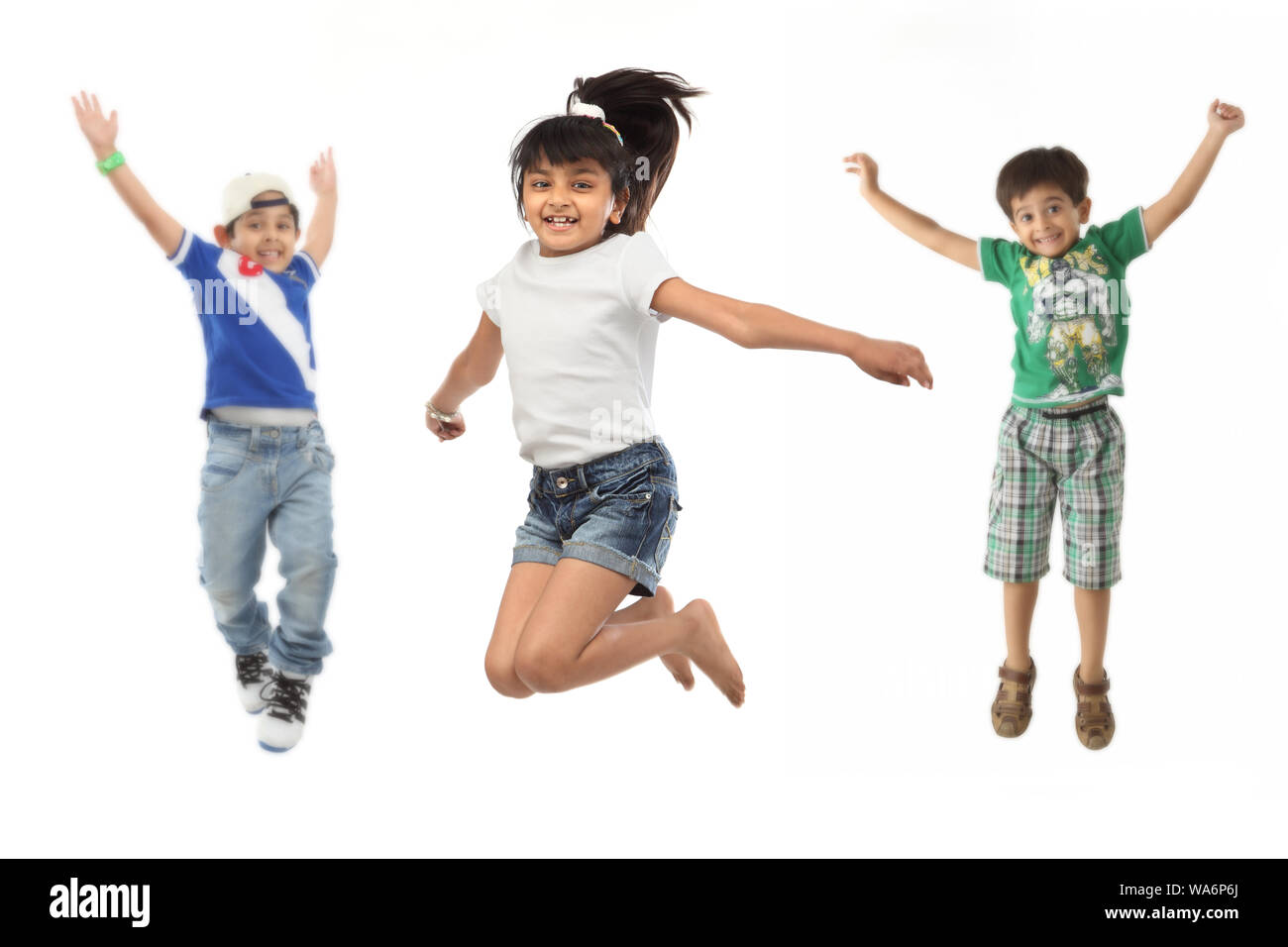 Groupe d'amis sautant dans l'air avec le bras tendu Banque D'Images