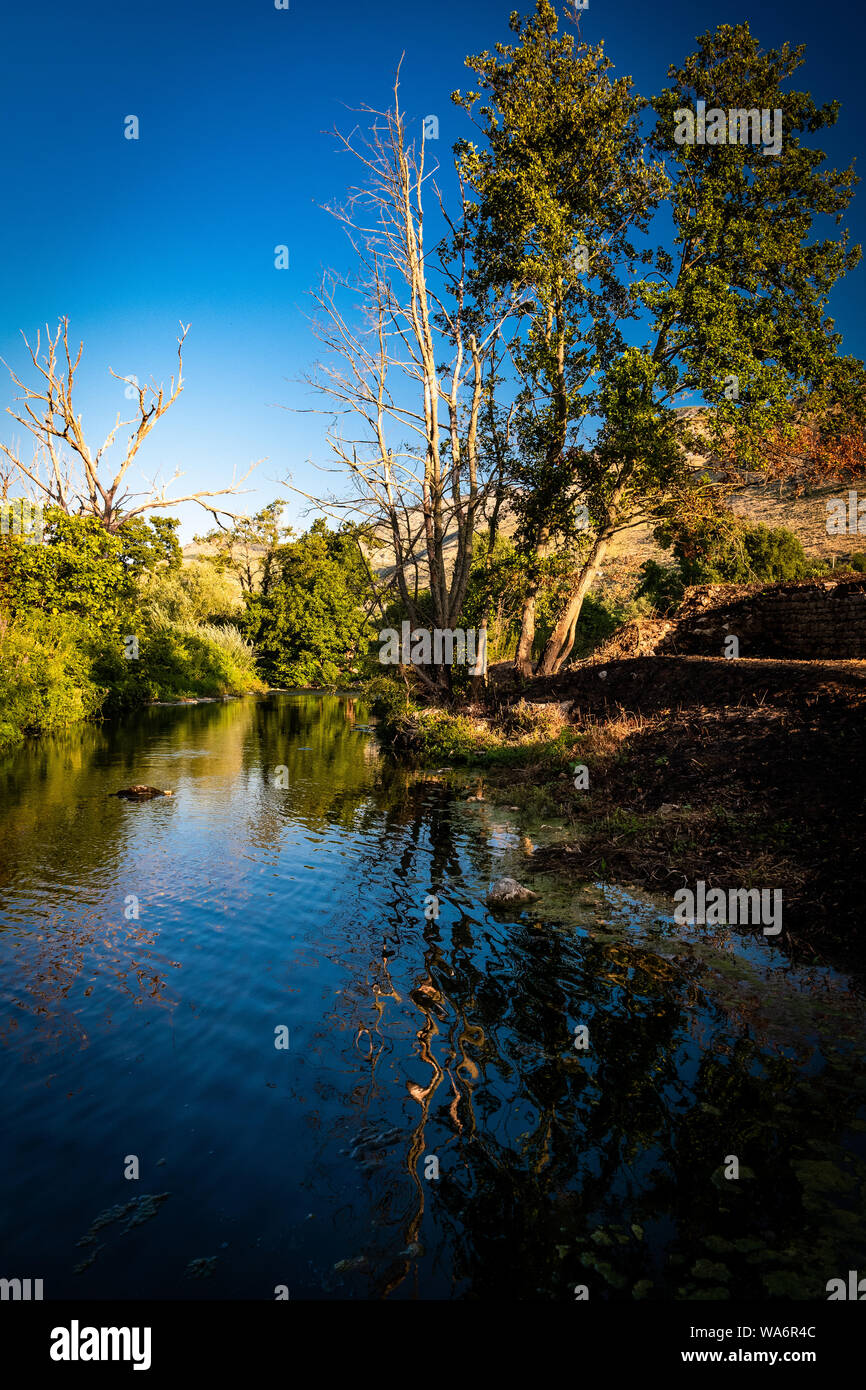 Rivière paisible dans la campagne italienne avec des réflexions des arbres dans l'eau Banque D'Images