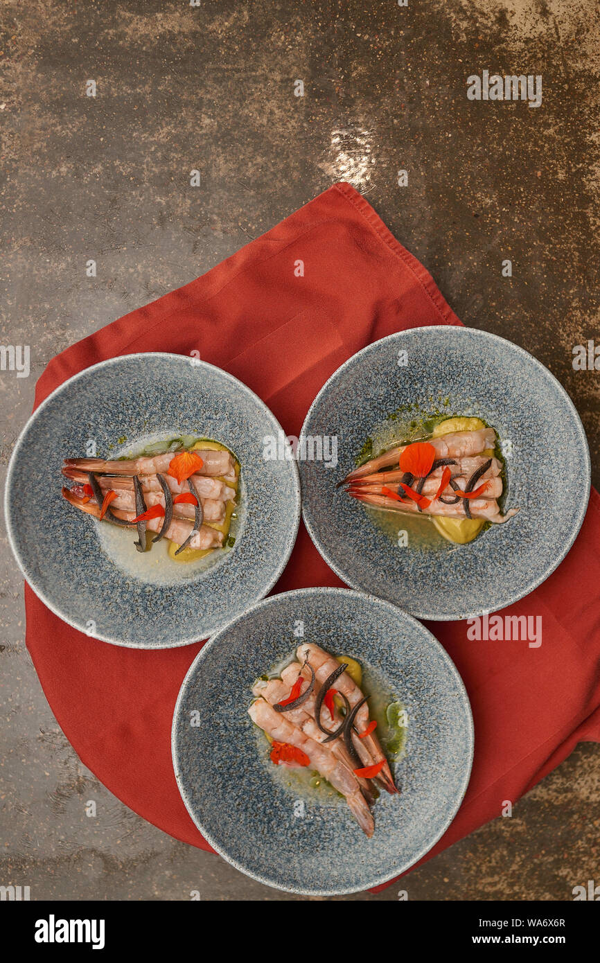 De nombreuses planches aux crevettes sur une table de cuisine dans un restaurant. Banque D'Images