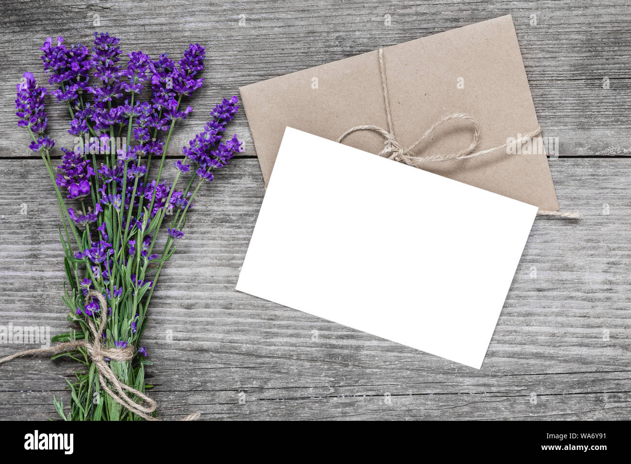 Carte de voeux blanche avec des fleurs de lavande et de l'enveloppe sur la table de bois rustique. Télévision. vue d'en haut.. la maquette ou mariage womens day background Banque D'Images