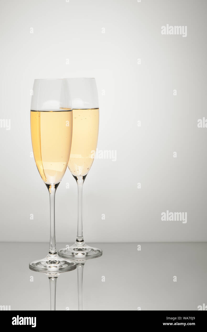 Deux verres de champagne avec réflexion isolé sur fond blanc. Chemin de détourage inclus. Banque D'Images