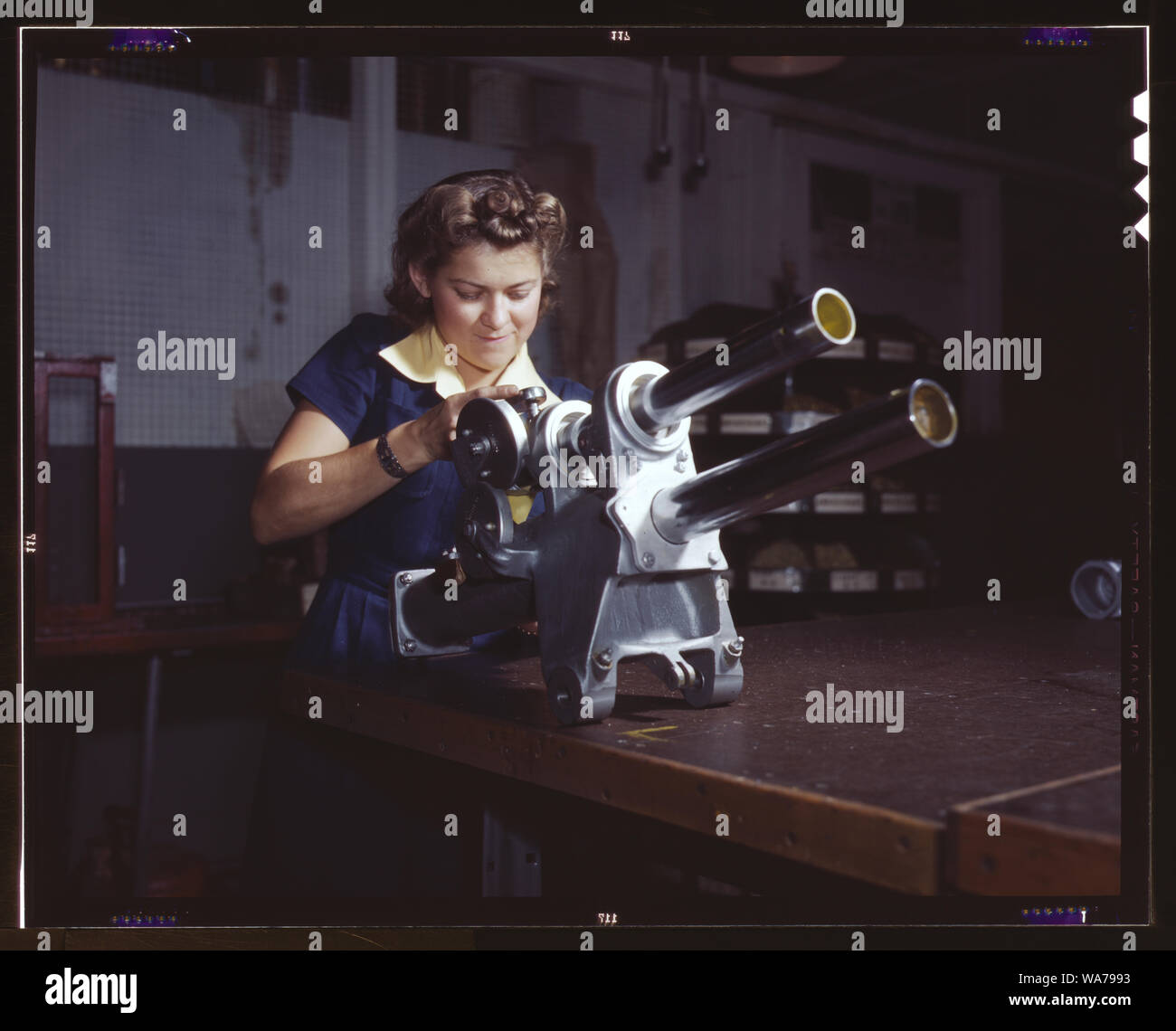 Une jeune femme employée de North American Aviation, Incorporated, travaillant sur le mécanisme d'atterrissage d'un avion de chasse P-51, Inglewood, Californie Le mécanisme ressemble à un petit Cannon Banque D'Images