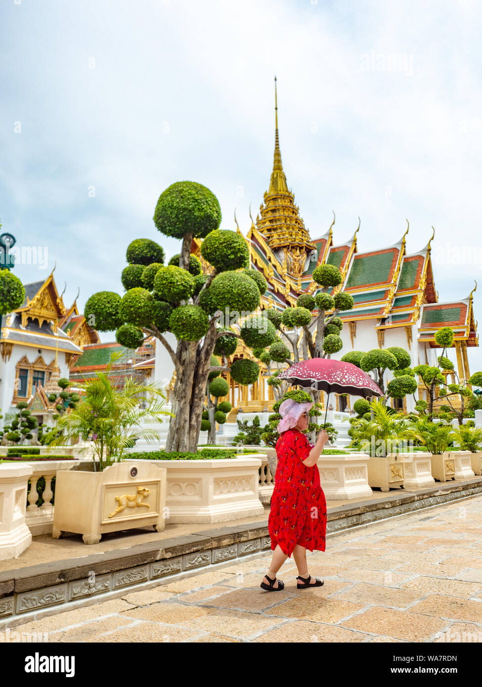 Bangkok, Thaïlande - juin 2019 : une femme asiatique non identifiée en rouge, tenant un parapluie, visite du Palais Royal Banque D'Images