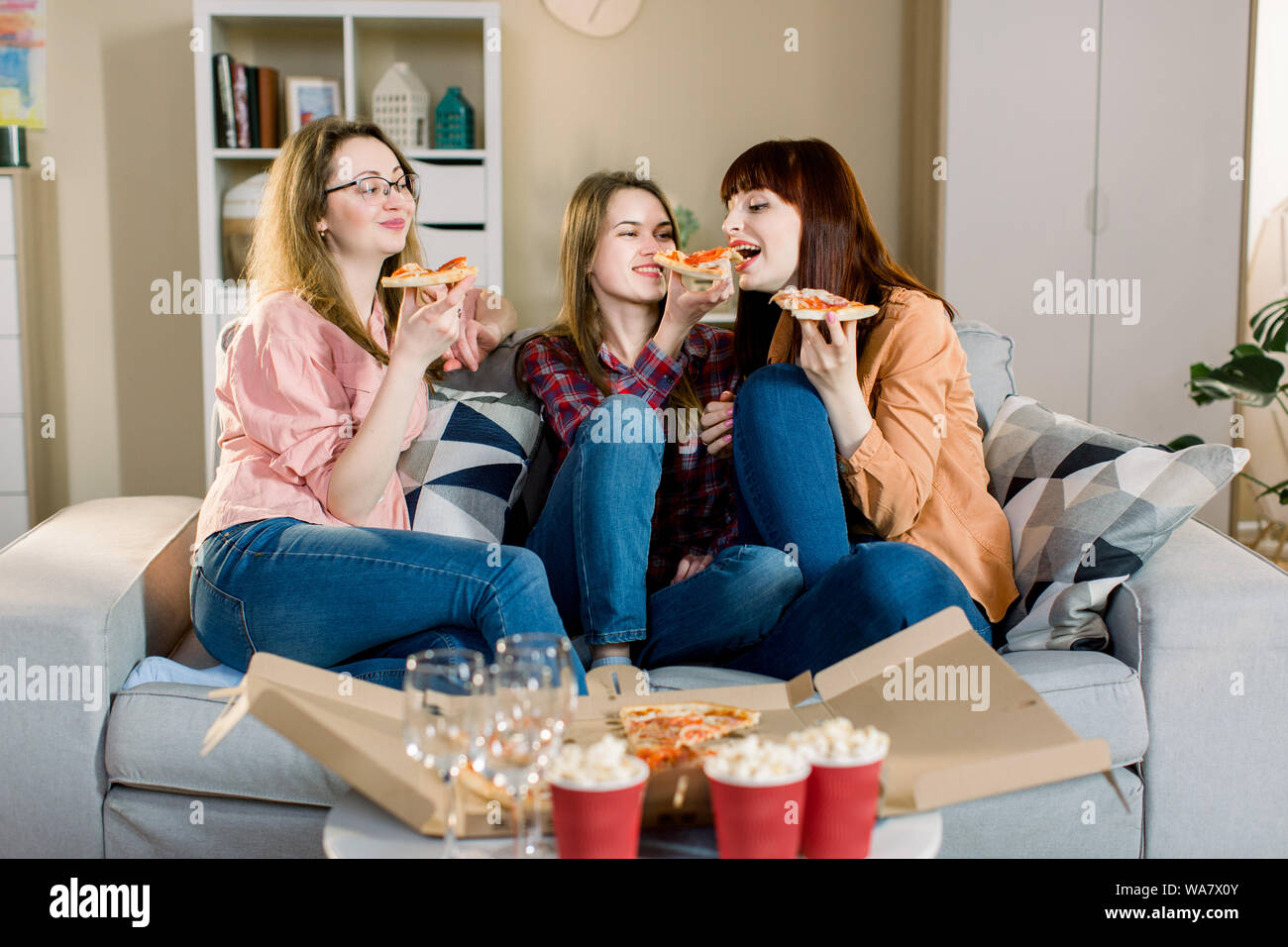 De belles jeunes filles en jeans et jupes eating pizza,parler et sourire à  la maison. Friends Eating Pizza, amitié, personnes, soirée pyjama,  entertainm Photo Stock - Alamy