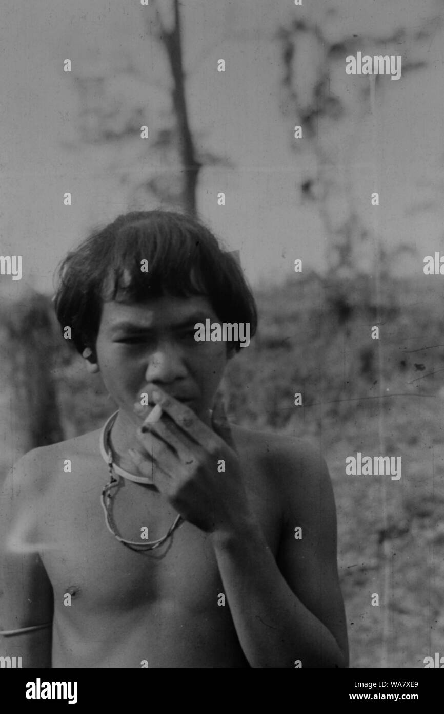 AJAXNETPHOTO. 1953-1957 (environ). INDO CHINE. Le VIETNAM. (Dans le pays EMPLACEMENT INCONNU.) - Une tribu du Montagnard, peut-être, de fumer une cigarette. PHOTO:JEAN CORRE/AJAXREF:RX7  256 191508 Banque D'Images