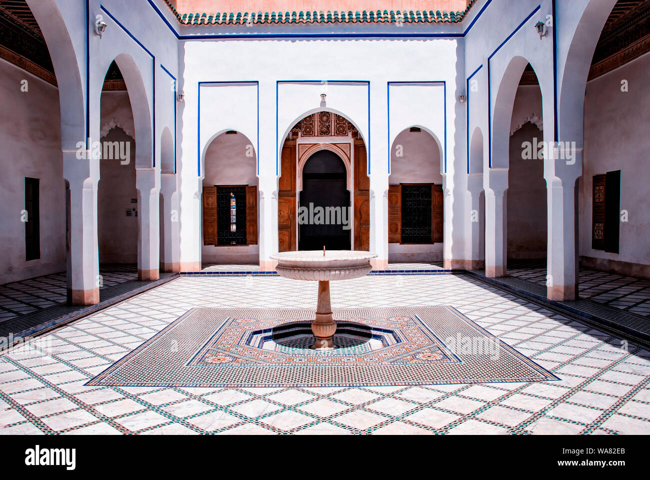 Courtyard at El Palais Bahia, Marrakech, Maroc. il y a des murs blancs et des colonnes avec des panneaux bleus et blancs de la fontaine. Banque D'Images