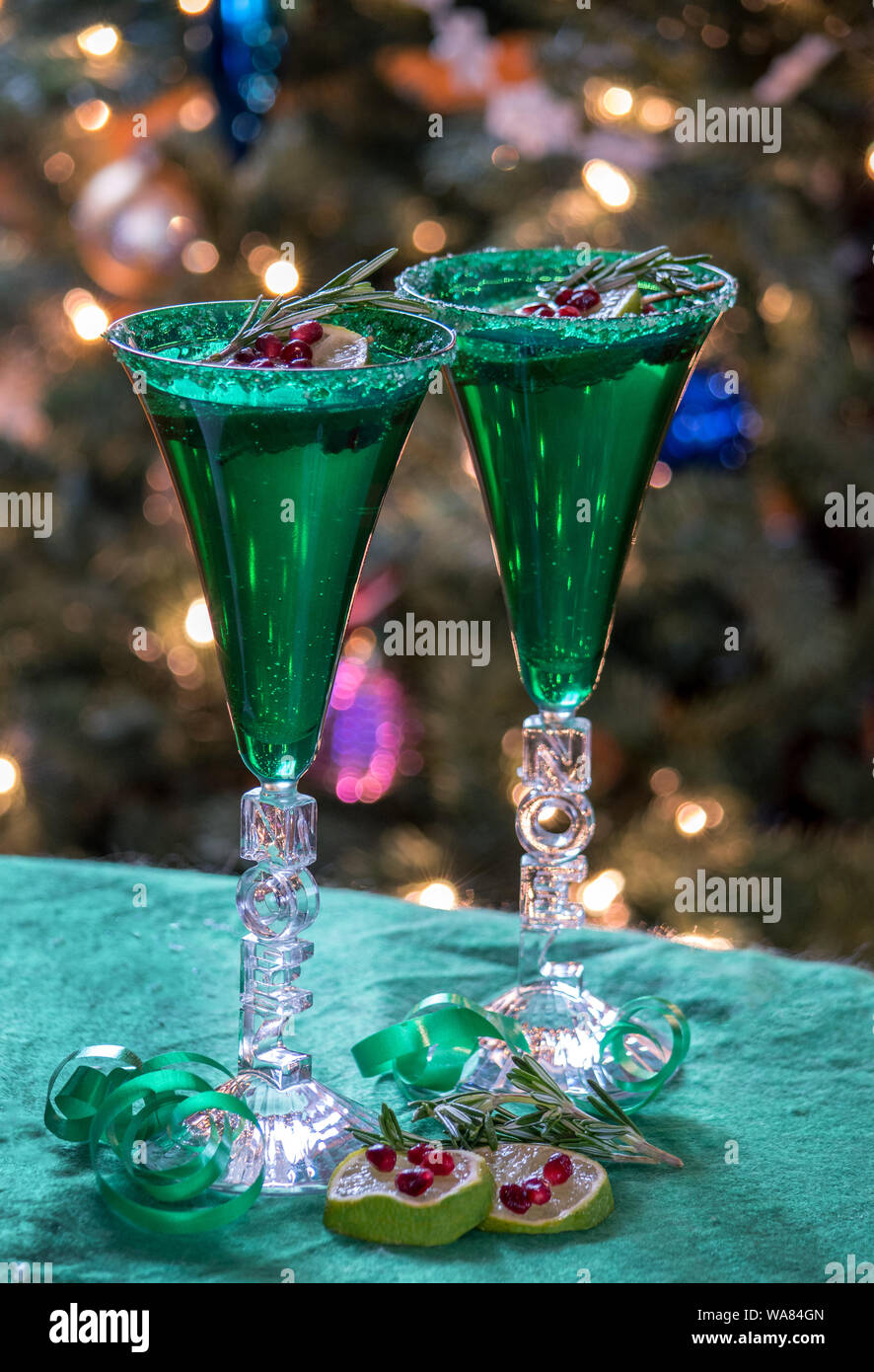 Noël spécial flutes que dire Noel, Champagne pétillant est garni d'une branche de romarin, tranche de lime, et graines de grenade Banque D'Images