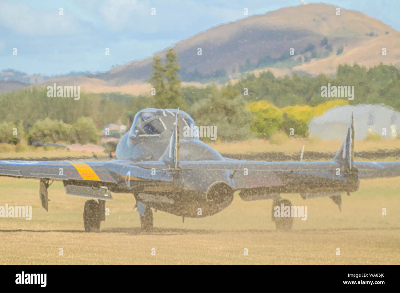 De Havilland Vampire jet avion à ailes au-dessus de l'Aérodrome de capot, airshow Wairarapa, Masterton, Nouvelle-Zélande. Il roulait sur l'herbe l'explosion de l'herbe coupée Banque D'Images