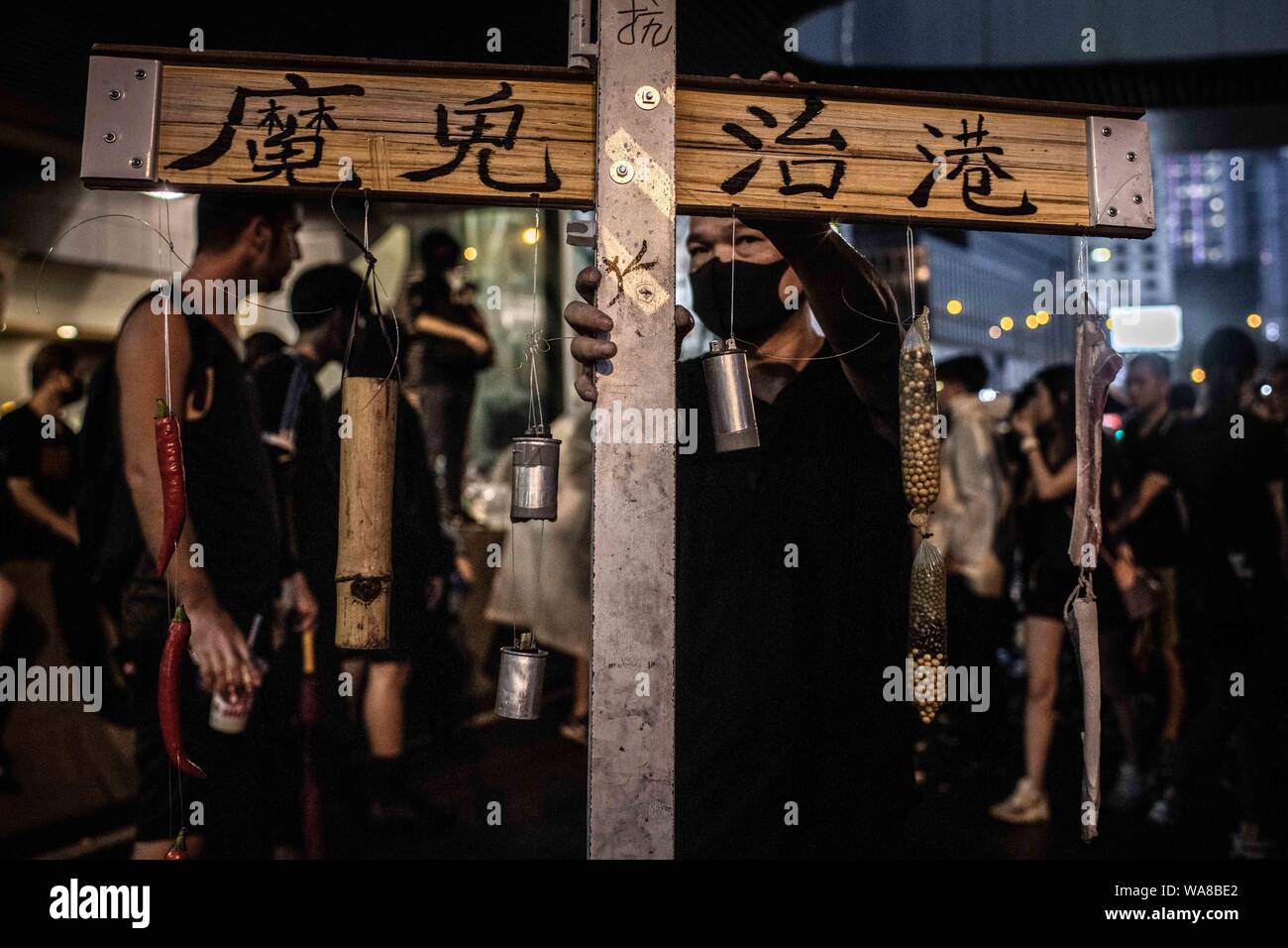 Un manifestant est titulaire d'une croix en bois avec l'inscription "le mal régit Hong Kong' pendant la démonstration.Les manifestants sont descendus dans la rue sur un dimanche pluvieux dans une manifestation pro-démocratie sur l'île de Hong Kong, ils exigent le retrait complet de la loi sur l'extradition et le gouvernement à mettre en place une enquête indépendante sur les récents affrontements entre manifestants et policiers - Les organisateurs ont déclaré que c'était le plus grand rassemblement au cours de la semaine. Banque D'Images