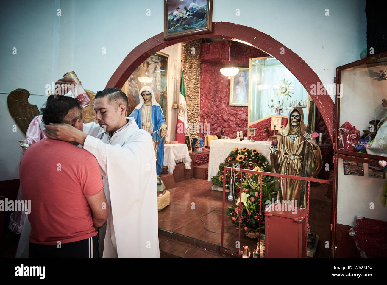 Les dévots de Nuestra Señora de la Santa Muerte (Notre Dame de la sainte mort) Visitez l'Église Santuario Nacional del Angel de la Santa Muerte Tepito, dans la ville de Mexico. Santa Muerte est le saint patron des criminels, des prostituées, des drogués, et tous ceux oubliés par la société. Une personnification de la mort, elle est associée à la guérison, la protection et la prestation sécuritaire de l'au-delà par ses dévots. Banque D'Images