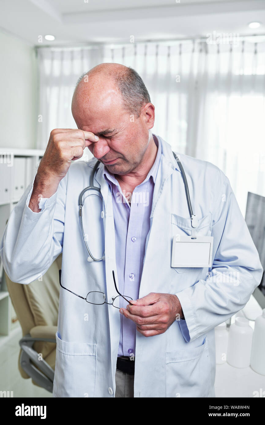 Souligné médecin souffrant de graves maux de tête après la difficile journée de travail Banque D'Images