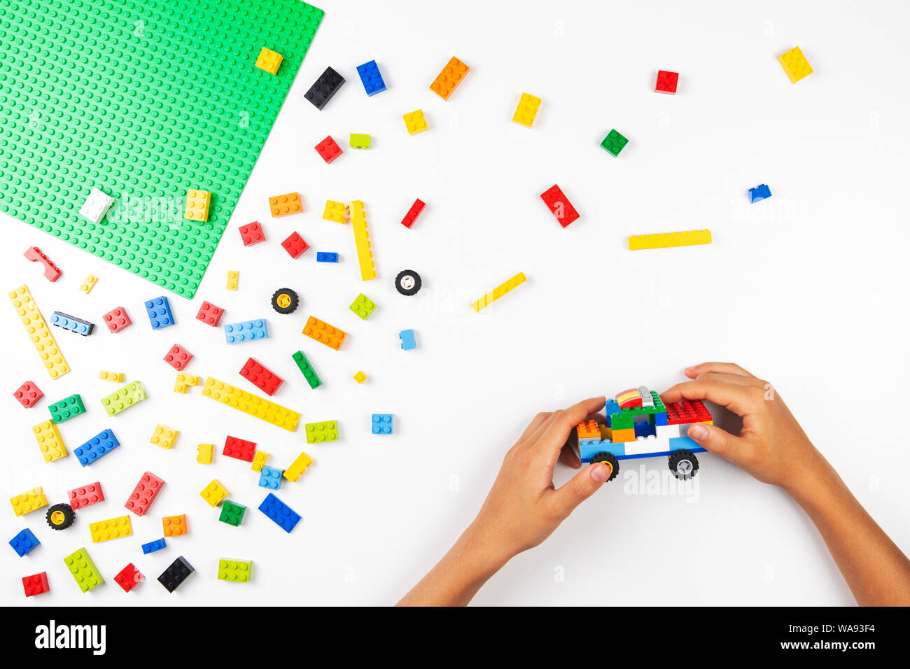 Vilnius, Lituanie - 17 août, 2019 : les mains de l'enfant jouer avec des blocs de Lego et de faire de nouvelle voiture sur tableau blanc Banque D'Images